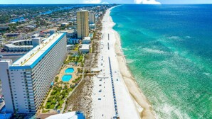 A coastal hotel with a long beachfront, multiple swimming pools, and a large building with a blue roof. - Summit 808 - Luxury Beach Resort Condo 1-6 People (Panama City Beach)