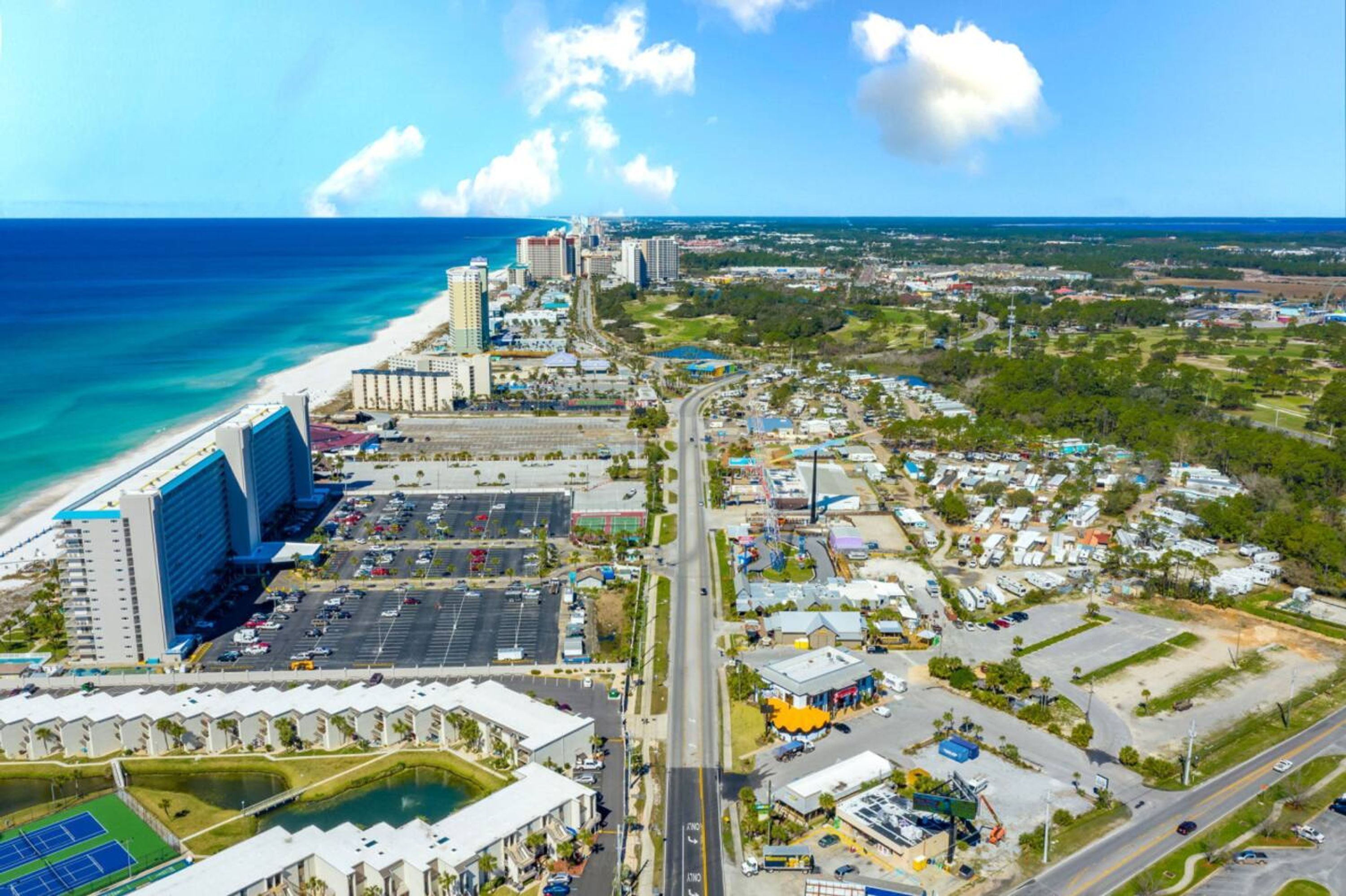 Ein Luftbild einer Küstenstadt mit Strand, Hochhäusern und einer Mischung aus Gewerbe- und Wohngebieten.