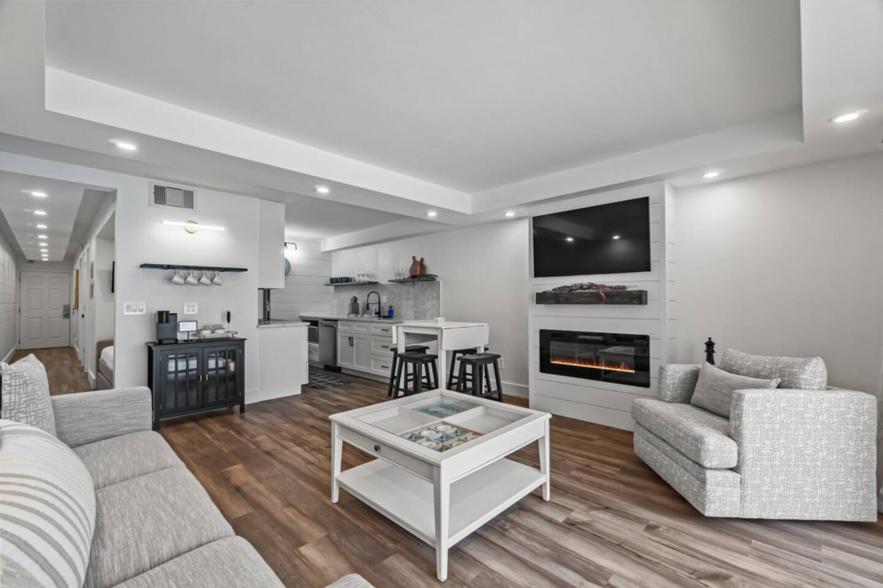 Un salon moderne avec un canapé, une table basse et une cheminée.