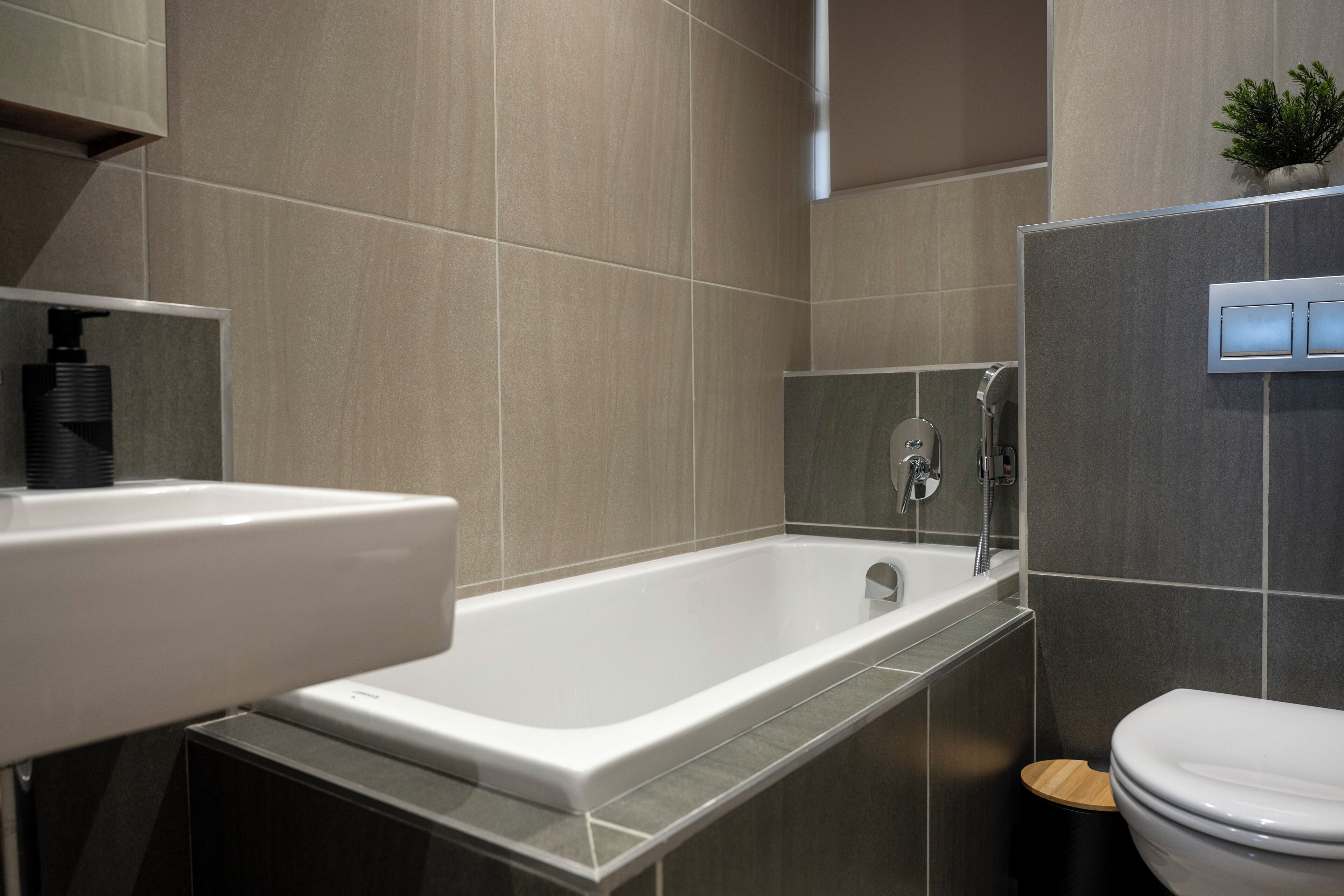 Ein modernes Badezimmer mit Badewanne, Waschbecken und Toilette.