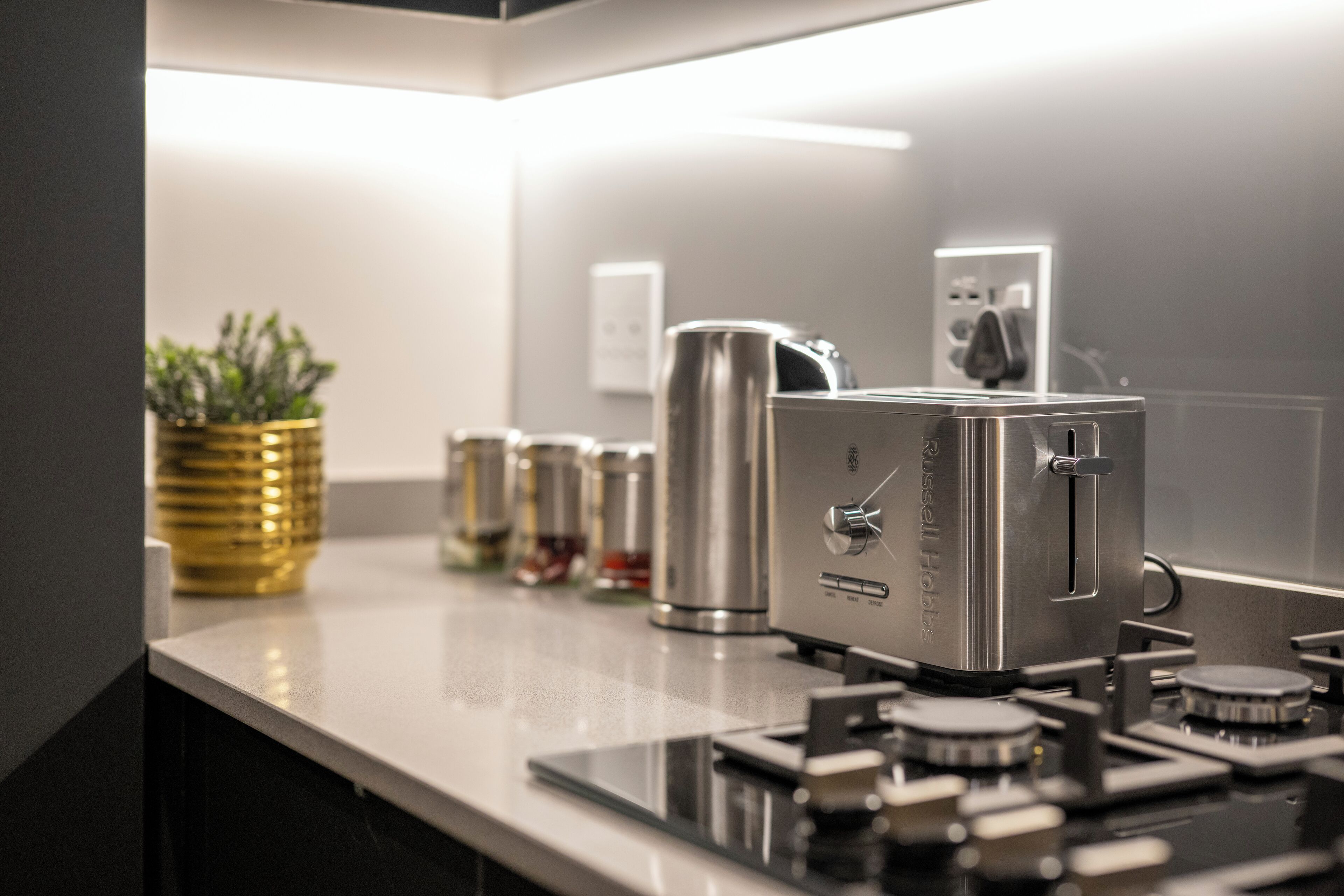 A modern kitchen with stainless steel appliances, a coffee machine, and a kettle.