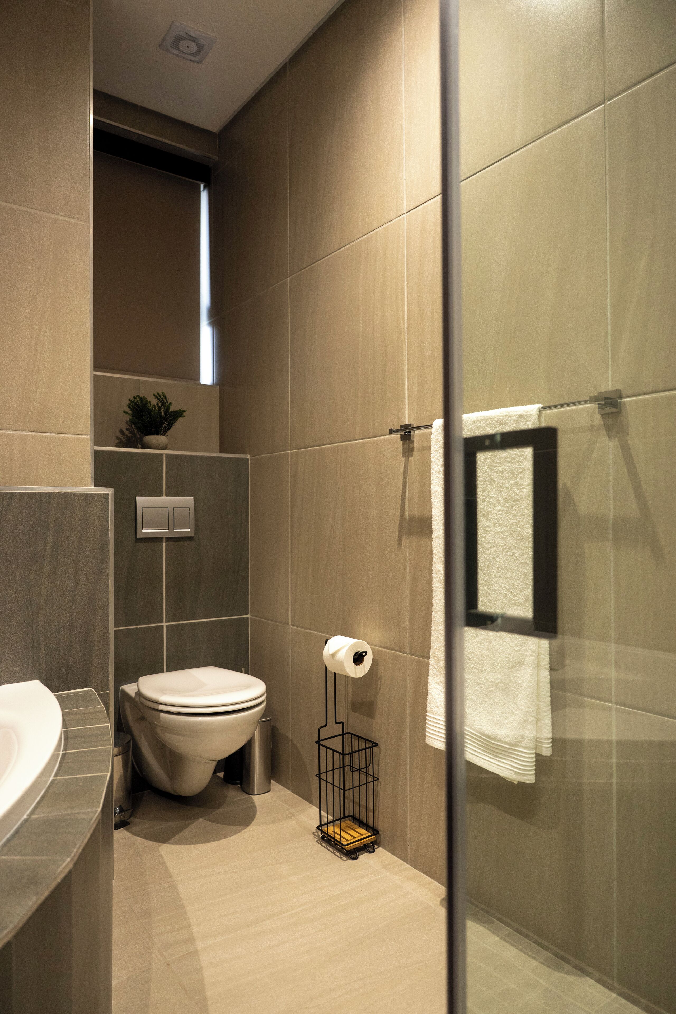 Un baño moderno con inodoro, lavamanos y cabina de ducha de vidrio.