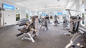 A gym with various exercise equipment, large windows, and a ceiling fan. - Introducing The Barefoot Villa in Lost Key! For An Upscale-Coastal Vacation. (Pensacola)