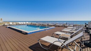 A pool area with lounge chairs and a view of the ocean. - Introducing The Barefoot Villa in Lost Key! For An Upscale-Coastal Vacation. (Pensacola)