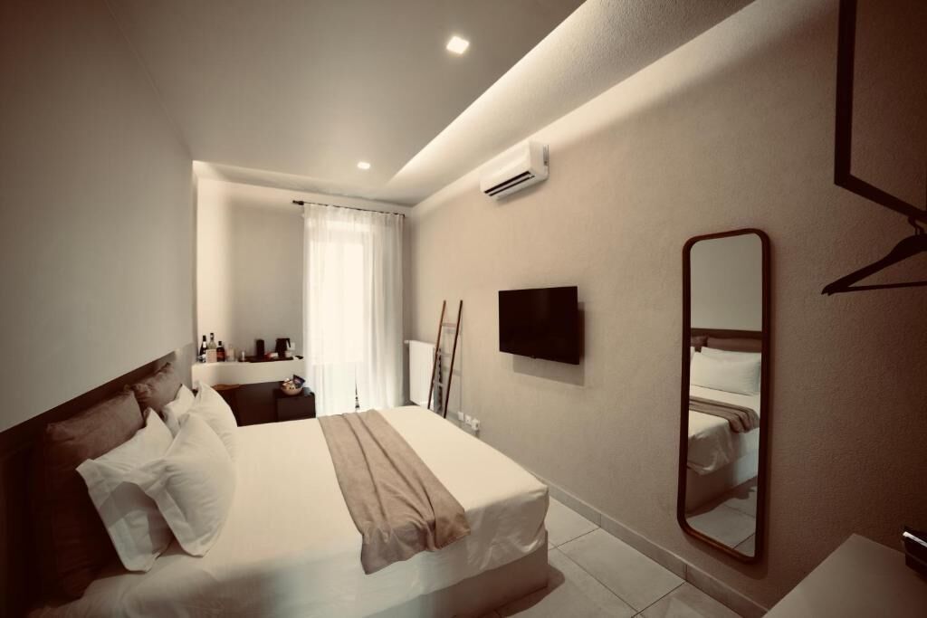 Une chambre d’hôtel équipée d’un lit, d’une télévision, d’un miroir et d’un appareil de climatisation.