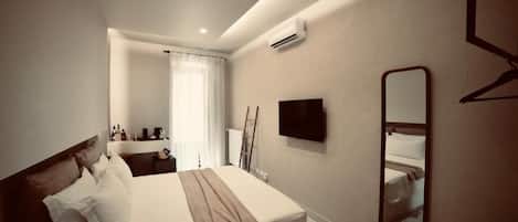 Une chambre d’hôtel équipée d’un lit, d’une télévision, d’un miroir et d’un appareil de climatisation.