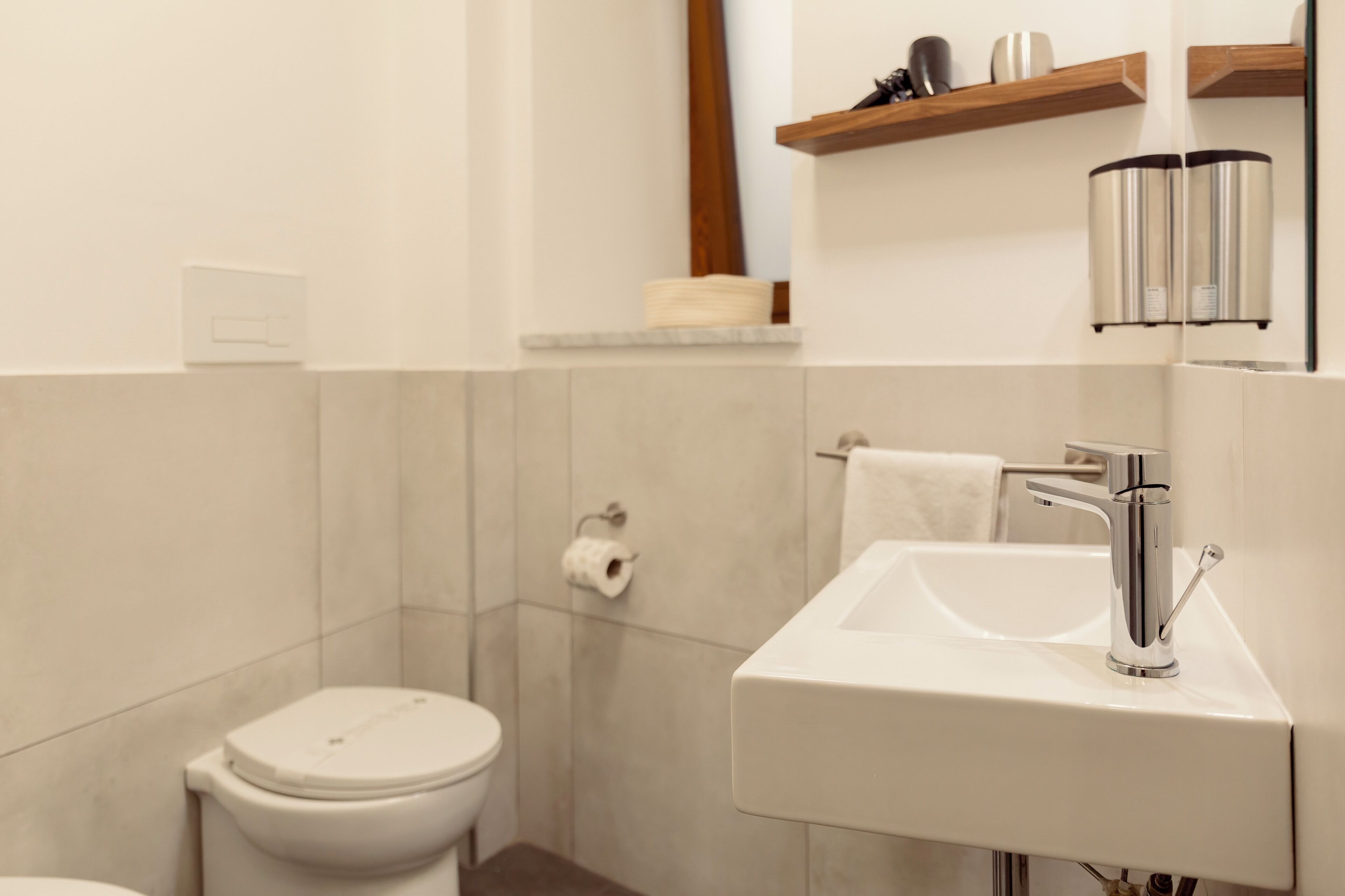 A modern bathroom with a toilet, sink, and towel rack.