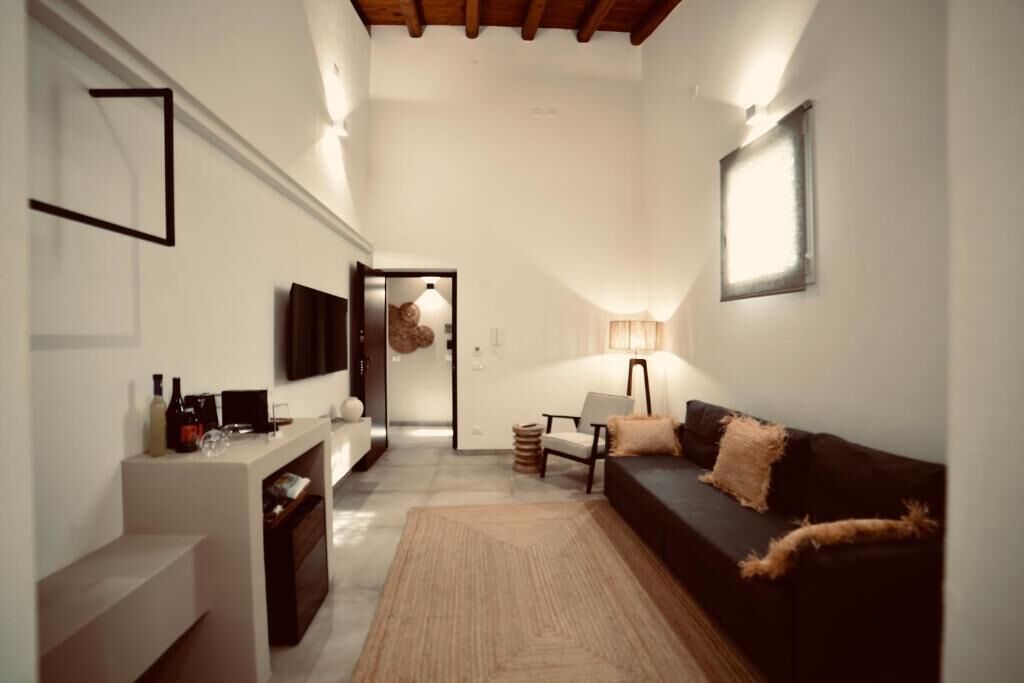 A modern living room with a sofa, a coffee table, a TV, and a lamp.