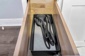 A drawer with a black plastic container holding kitchen utensils. - Sunny Tampa Home Near Downtown Stadiums (Tampa)