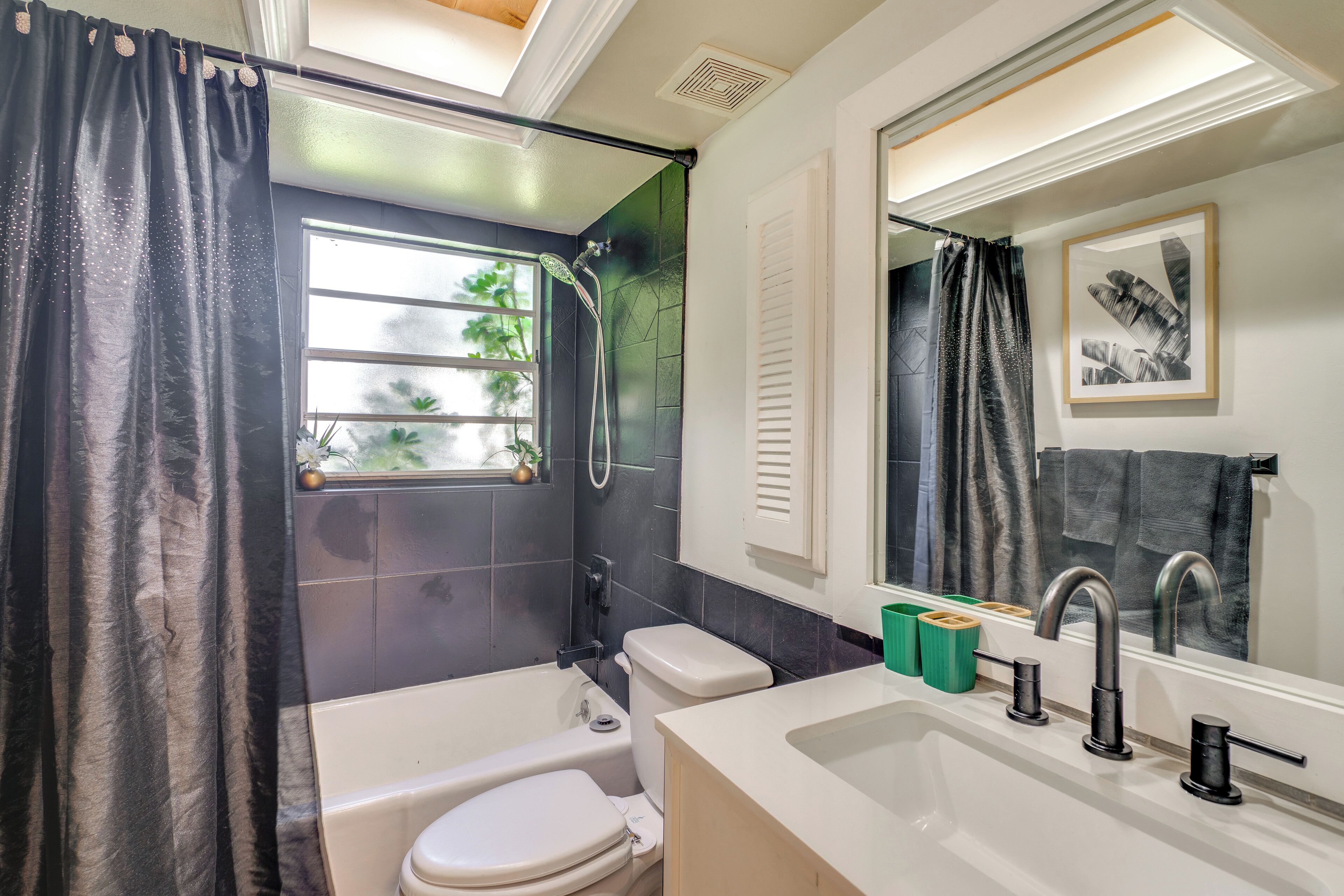 A modern bathroom with a bathtub, toilet, and sink.
