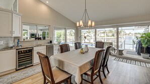 A spacious kitchen with a large dining table, modern appliances, and large windows offering a view of the outdoors. - 2 Mi to South Beach: Waterfront Home w/ Lanai! (Marco Island)