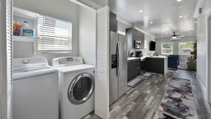 A laundry area with a washing machine and dryer, a refrigerator, and a microwave. - Walk to UC Davis Medical Center! Duplex w/ Patio (Sacramento)