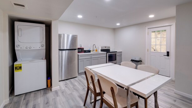 A compact kitchen with a refrigerator, microwave, stove, and sink. There is a dining table with chairs. - 2 Mi to Umd: Apt w/ Free Parking in Silver Spring! (Silver Spring)