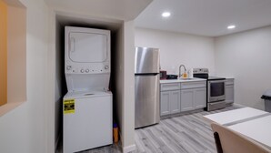 A compact kitchen with a washer-dryer unit, stainless steel refrigerator, microwave, sink, and oven. - 2 Mi to Umd: Apt w/ Free Parking in Silver Spring! (Silver Spring)