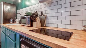A modern kitchen with a wooden countertop, a built-in microwave, a knife block, and a roll of paper towels. - Commuter-friendly Vancouver Rental w/ Yard (Vancouver)