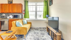 A compact living space with a kitchenette, a sofa, a television, and a view of the outside. - Quiet Newark Apt Near Colleges, Arenas & Hospitals (Newark)