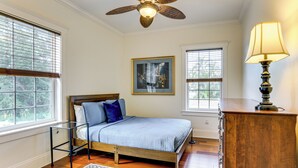 Ein Schlafzimmer mit Bett, Deckenventilator, Lampe und Kommode.