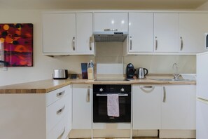 A kitchen with white cabinets, a Bosch oven, a coffee maker, and a toaster. - Inviting 1BD Flat in the Heart of East London (Greater London)