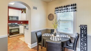A dining area with a table set for four, a clock on the wall, and a 'WELCOME' sign. - Walk Everywhere! Dtwn Washmo Home Near Wineries (Washington)