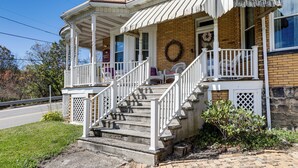 A two-story house with a porch, a staircase, and a brick exterior. - Groups Welcome! Historic Queen Anne Gem in Garrett (Garrett)
