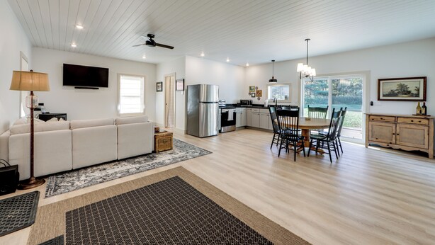 A modern kitchen with a dining area, white walls, and wooden flooring. - Near All-season Trails! Modern Copenhagen Cabin (Copenhagen)