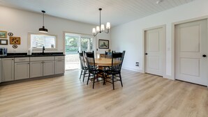 A spacious kitchen with a wooden dining table and chairs, white cabinets, and a pendant light. - Near All-season Trails! Modern Copenhagen Cabin (Copenhagen)