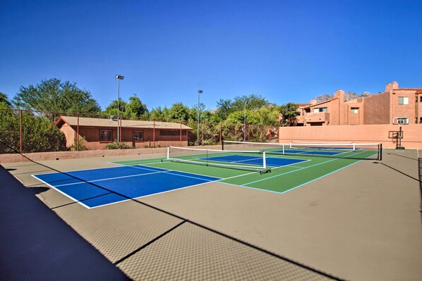 An outdoor tennis court with a net, surrounded by buildings and trees. - 3 Mi to Sabino Canyon: Condo w/ Resort Perks! (Tucson)