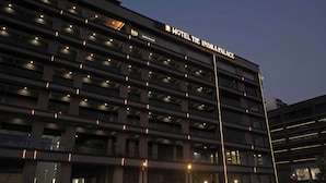 Un immeuble d’hôtel à plusieurs étages, doté d’une enseigne lumineuse indiquant « Hôtel The Indra Palace ».