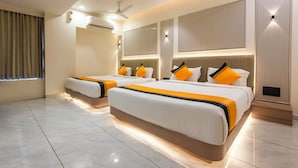 Une chambre d’hôtel moderne équipée de deux lits, d’un ventilateur de plafond, d’un appareil de climatisation et d’une grande fenêtre avec des rideaux.