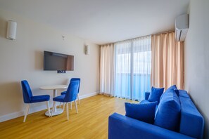 Departamento familiar, balcón, vista al mar | Área de sala de estar | Televisión de pantalla plana de 81 cm con canales por cable 