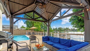 A covered outdoor area with a pool, a grill, and seating. - Lakefront Pool Family Home in Hollywood 10 minutes to HardRock stadium  (Pembroke Pines)