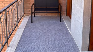 A bench against a brick wall with a metal railing and a door. - DA VINCI Residence - Between the Racetrack and the Historic Center (Imola)