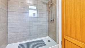 A shower area with tiled walls and a wooden door. - One Bed in Guilden Sutton by Guestz (Guilden Sutton)
