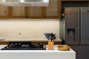 A modern kitchen with stainless steel appliances, wooden cabinets, and a built-in water dispenser. - Ipanema | Duplex no melhor local do bairro, 4 quartos, 5 min da Praia - por Casapē Rio (Rio de Janeiro)