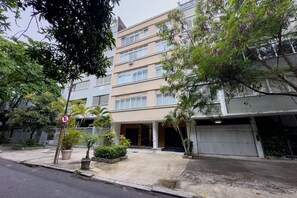 A multi-story residential building with a garage, a gated entrance, and a no parking sign. - Ipanema | Duplex no melhor local do bairro, 4 quartos, 5 min da Praia - por Casapē Rio (Rio de Janeiro)
