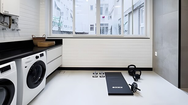 A compact kitchen with a washing machine, a window with a view of buildings, and a black exercise mat. - Ipanema | Duplex no melhor local do bairro, 4 quartos, 5 min da Praia - por Casapē Rio (Rio de Janeiro)