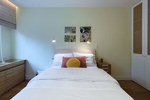 A bedroom with a bed, bedside tables, a dresser, and wall art. - Ipanema | Duplex no melhor local do bairro, 4 quartos, 5 min da Praia - por Casapē Rio (Rio de Janeiro)