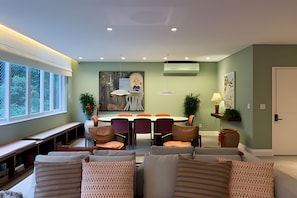 A modern living room with a dining area, a bench, and a door. - Ipanema | Duplex no melhor local do bairro, 4 quartos, 5 min da Praia - por Casapē Rio (Rio de Janeiro)