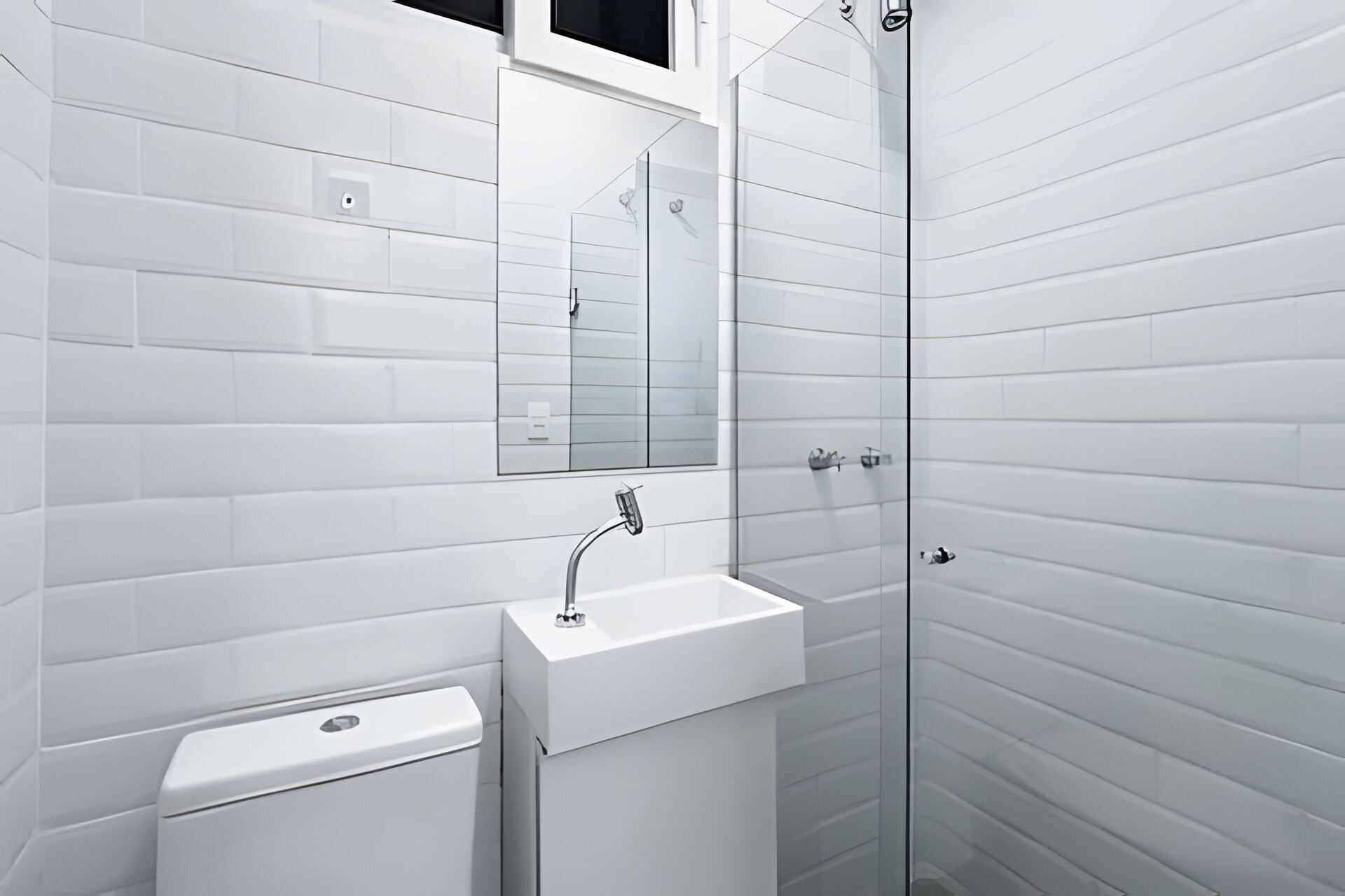 Un baño moderno con paredes de azulejos blancos, un lavabo, un espejo y una ducha.