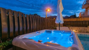 A hot tub with a stone wall and a wooden fence in the background. - Villa Old House - Makarska by Villas Guide (Lokvicici)