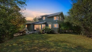 A two-story house with a front deck and a staircase leading to the entrance. - Secluded Woodland Retreat Near Starved Rock Park 4 Bedroom Home (Ottawa)