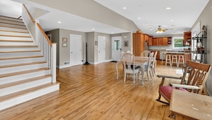 A spacious kitchen with wooden cabinets, a dining area with a table and chairs, and a staircase leading to another level. - Secluded Woodland Retreat Near Starved Rock Park 4 Bedroom Home (Ottawa)