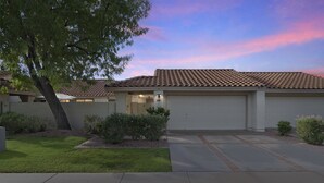 A residential house with a tiled roof, a garage, and a well-maintained lawn. - Chilled Tempe Oasis Shaded BBQ Lounge Near ASU 2 Bedroom Home (Tempe)