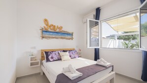 Ein Schlafzimmer mit einem Bett, einem Nachttisch, einer Wanddekoration und einem Fenster mit Blick.