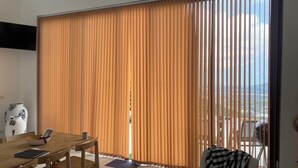 A modern room with a large sliding glass door leading to a balcony. There is a wooden dining table with chairs and a vase on the wall. - Great Sea view Mountain Villa (Koh Samui)
