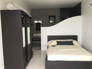 A bedroom with a bed, a wardrobe, and a bathroom visible through an open door. - Great Sea view Mountain Villa (Koh Samui)