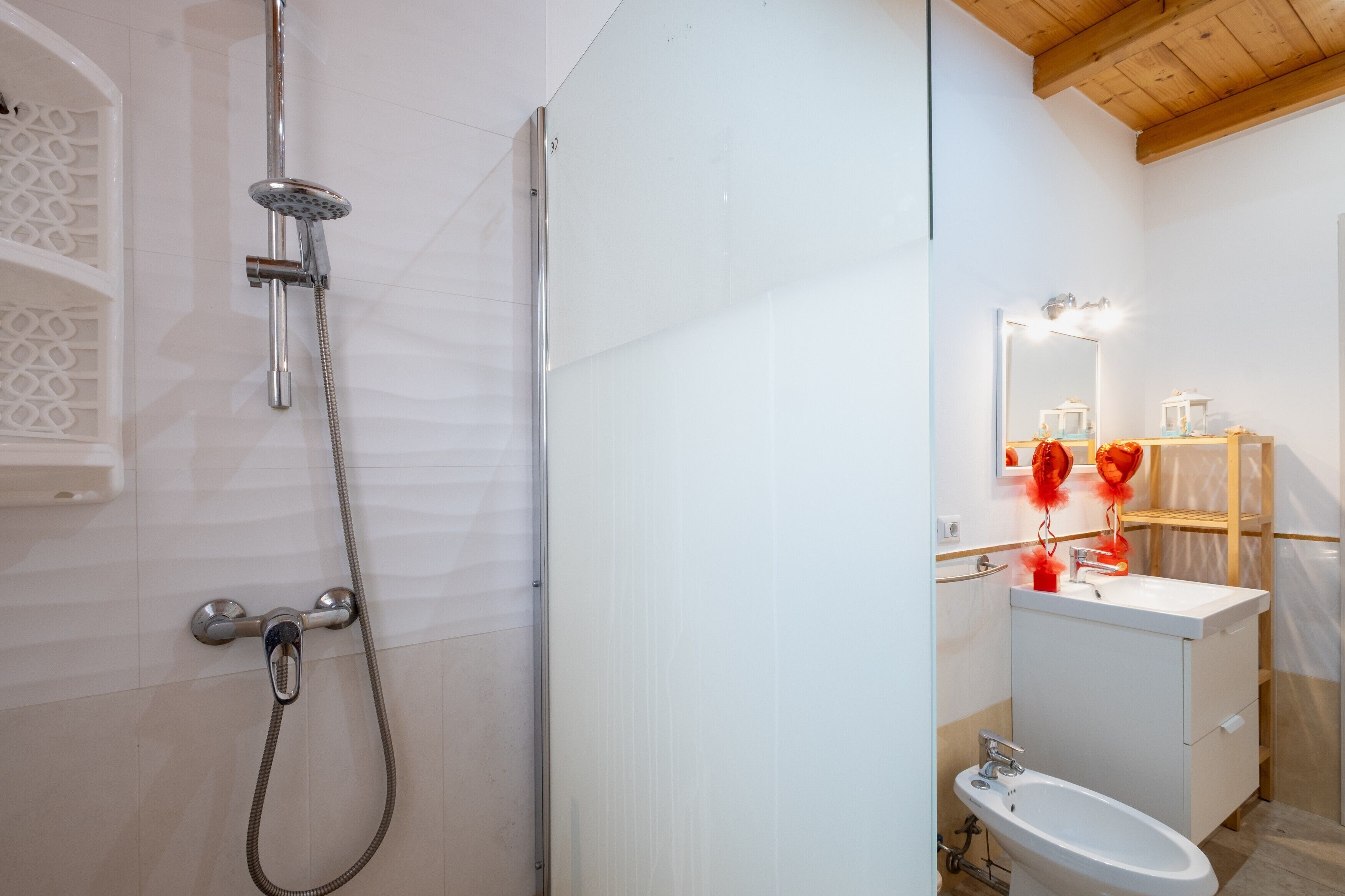 A bathroom with a shower, sink, and mirror.