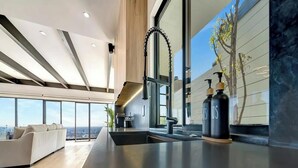 Una cocina moderna con un ventanal grande, horno empotrado y un grifo elegante.