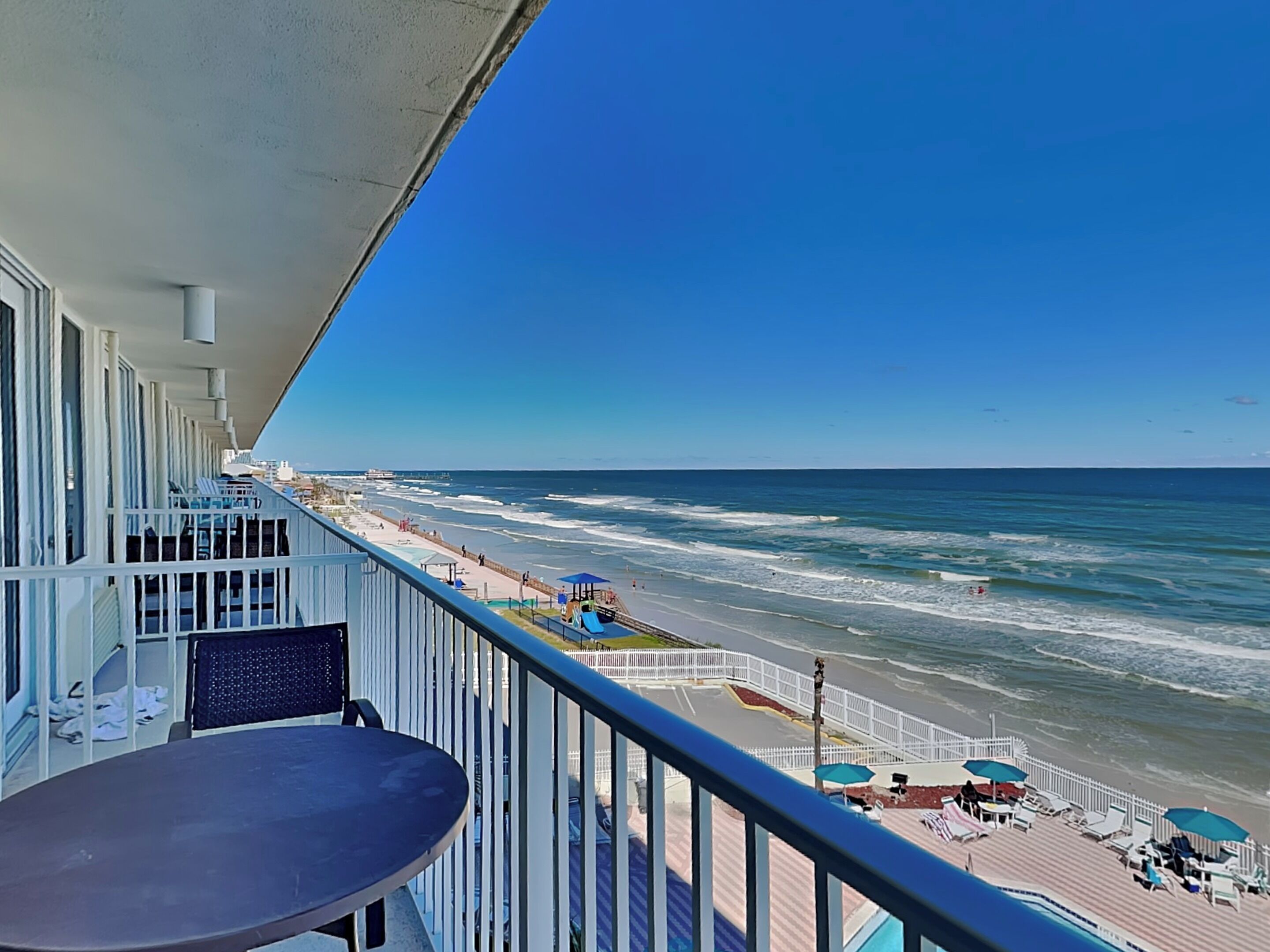 A balcony with a view of the ocean and beach.