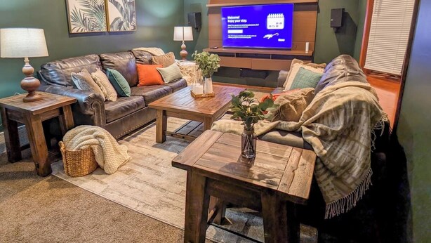 A living room with a sofa, coffee table, and TV. - The Pines at New Albany | Sleeps 8 | Acre Lot (New Albany)